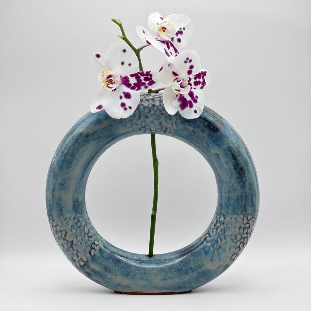 Handmade ceramic ring vase with orchid flower, blue rutile glaze, made in the Isle of Man by JFC Ceramics