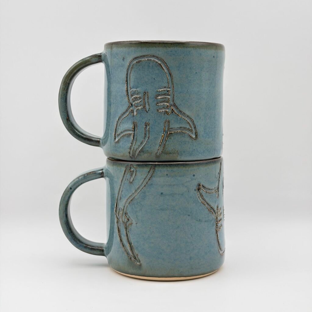 Two handmade ceramic mugs stacked with whale shark engraving in blue rutile glaze, JFC Ceramics